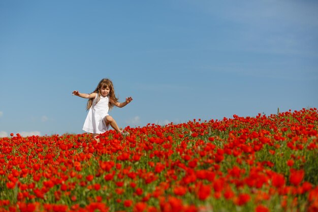 Bambina in un campo di papaveri