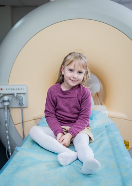 MRI 뇌 검사 전에 포즈를 취하는 어린 소녀