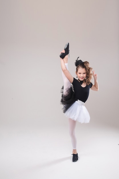 Little girl posing with her leg up in dancing costume.