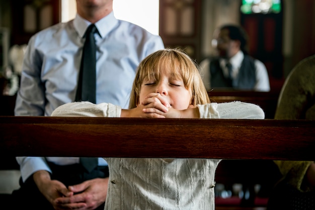 La bambina che prega la chiesa crede alla fede religiosa