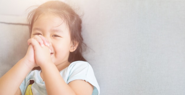 Foto bambina che prega. mani ripiegate nel concetto di preghiera per fede, spiritualità e religione.