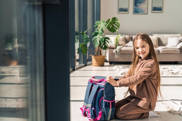 Little girl prepares school backpack