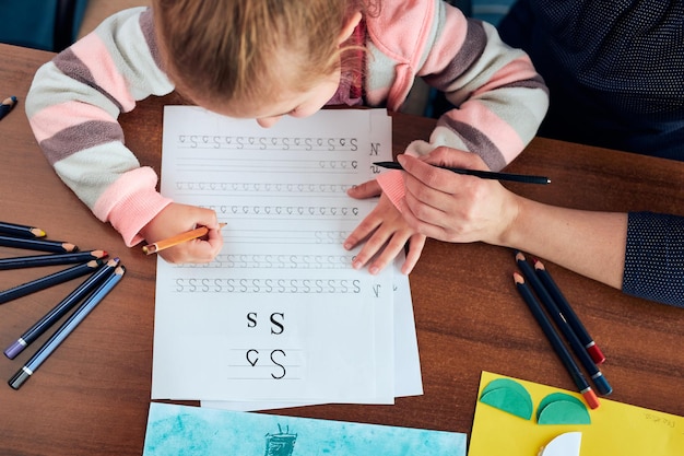 写真 母の手伝いで手紙を書くことを学ぶ幼稚園の女の子