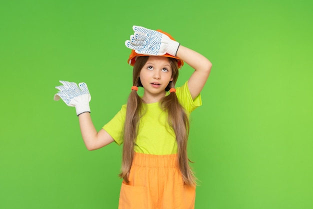 A little girl in a protective helmet and work gloves. very tired of repairs. Construction, repair, redevelopment of premises. copy space.