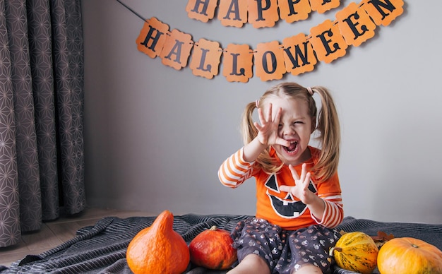 A little girl in a pumpkin costume for Halloween trick or treat Children celebrate Halloween girl is Ready for the trick or treat holiday