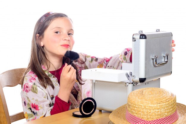 A little girl puts makeup