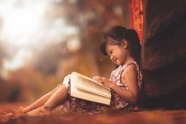 Книга чтения маленькой девочки в свободном времени с счастливым.