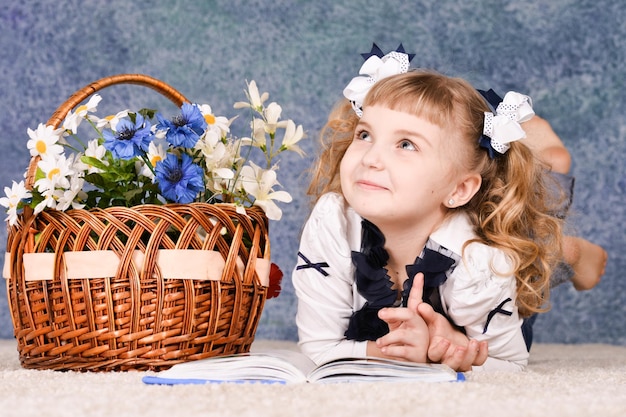 Little girl reading book while lying on floor