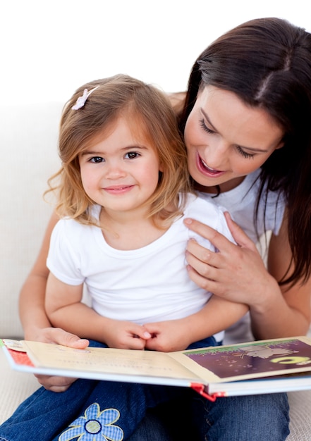 Little girl reading a book withher mother