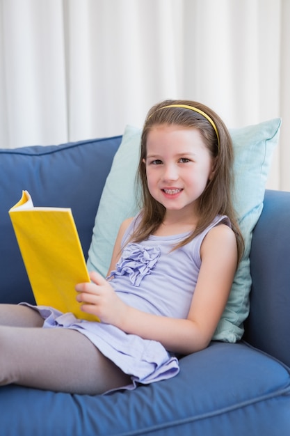 Little girl reading on couch