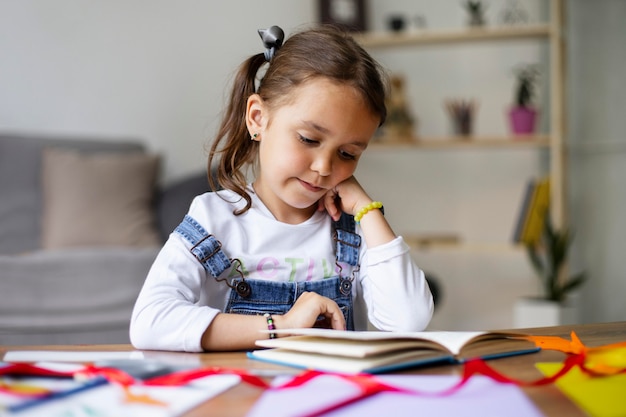 Photo little girl reading from a book