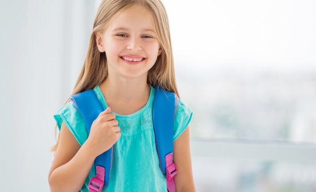 Little girl ready to go to school with backpack