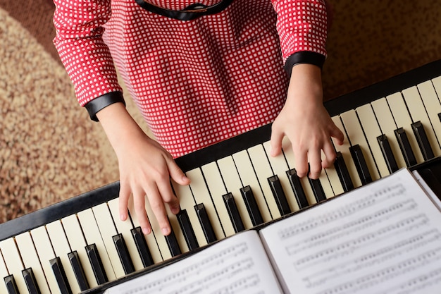 Little girl in red dress performing classical music