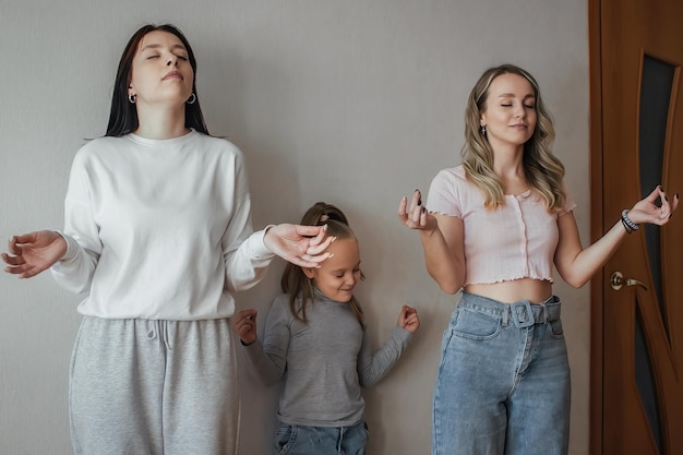 A little girl repeats meditation techniques after the adults in the family