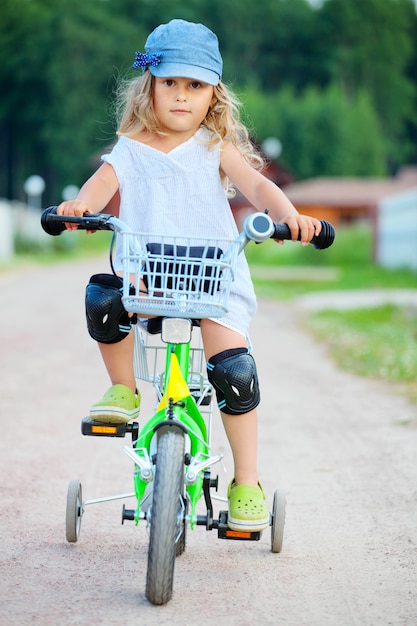어린 소녀는 자전거를 타고 여름 시간