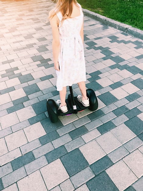 Giro della bambina su un hoverboard nel parco. vista posteriore