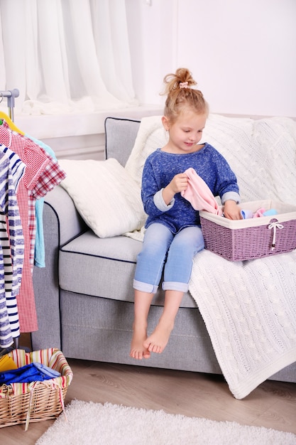 Little girl in the room with a lot of new clothes