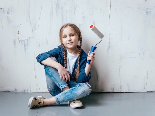 Little girl in a room with a wooden wall. Construction