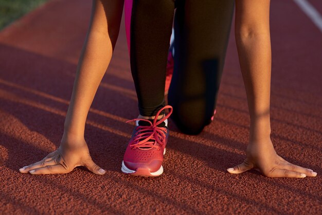 Little girl runner standing in start position before the sprint