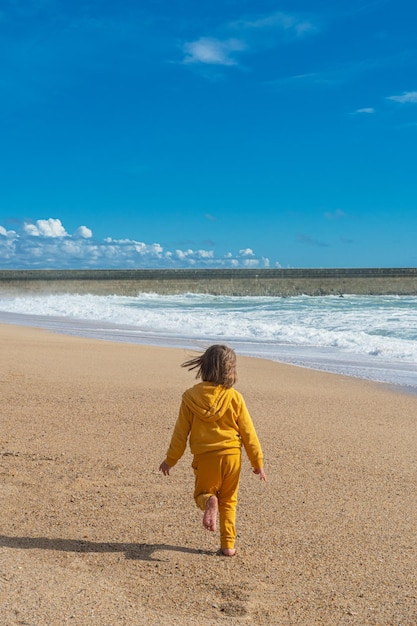 Little girl running near the sea