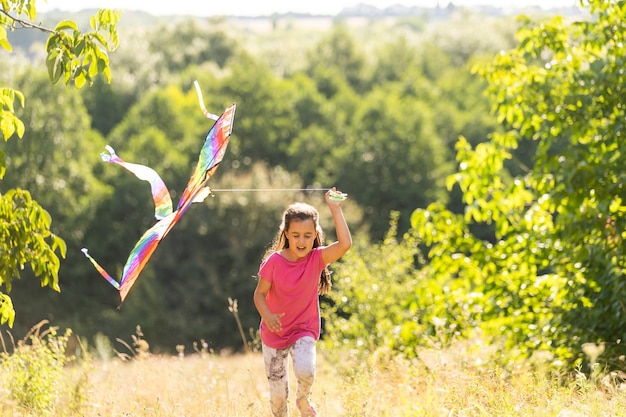 Bambina che corre all'aperto con un aquilone