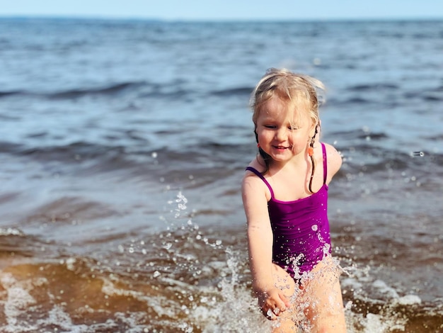 海で水しぶきで走っている少女