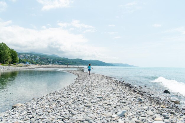 A little girl runs along the beach Summer