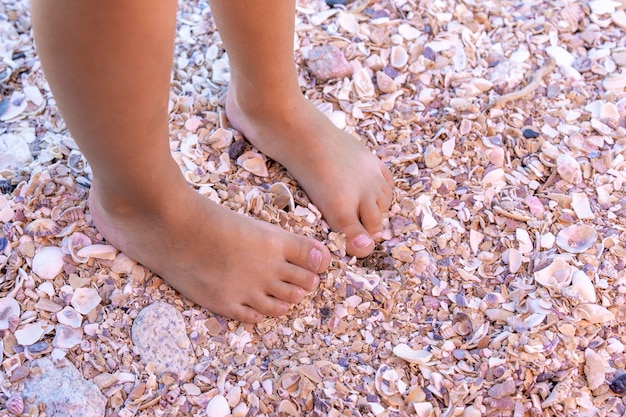 Foto i piedi della bambina sulla sabbia su una spiaggia