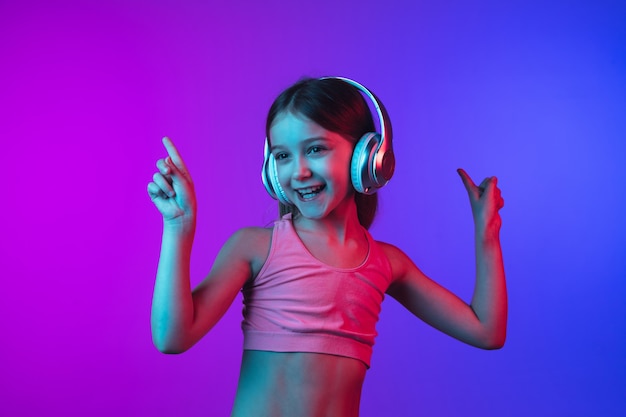 Little girl's portrait isolated on neon background