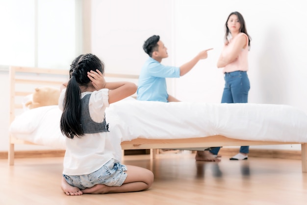 a little girl  sad with her parents are arguing in the background