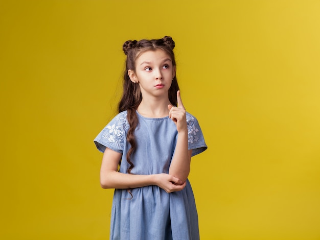 Foto dito indice di manifestazioni allegre sveglie castane della scolara della bambina bello su.