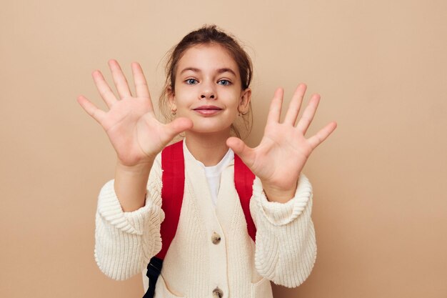 Little girl schoolgirl with red backpack posing childhood unaltered