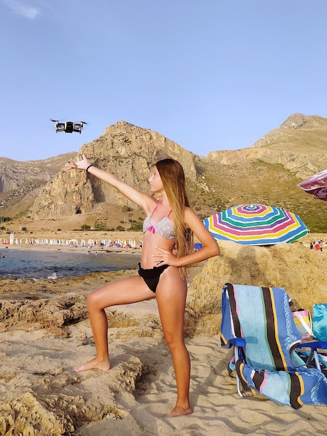 Photo little girl at the seaside plays with a drone