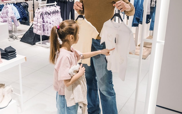 little girl shopping with parent in clothing store during daytime
