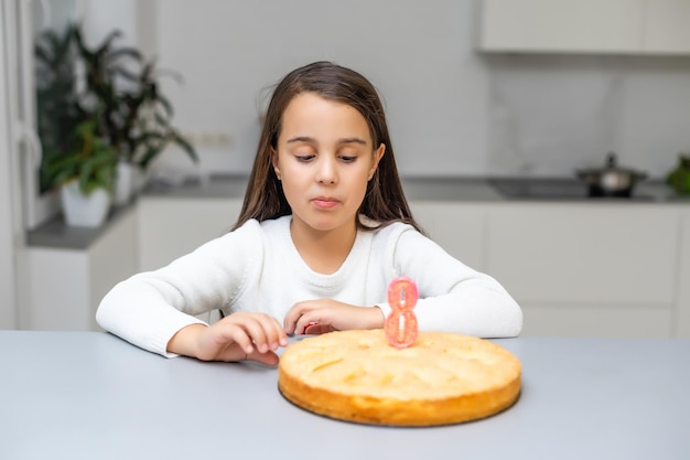 Bambina che mostra la torta di mele che ha cotto