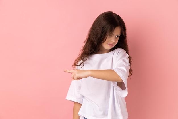 Little girl showing exit demanding to leave her alone turning away with irritated expression