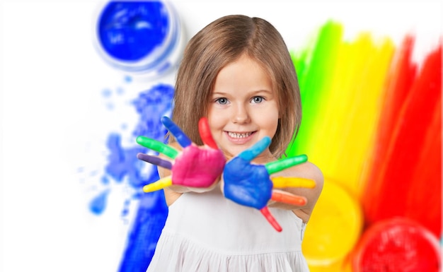 Little girl showing painted hands on bright background