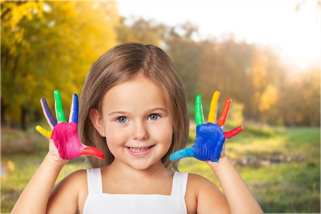little girl showing painted hands on bright background