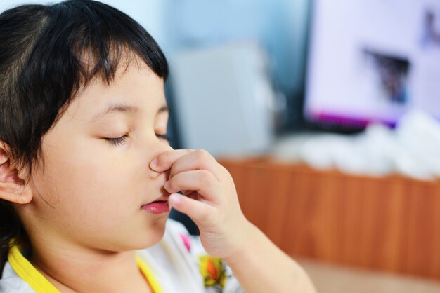 Little girl sick with hand holding her nose