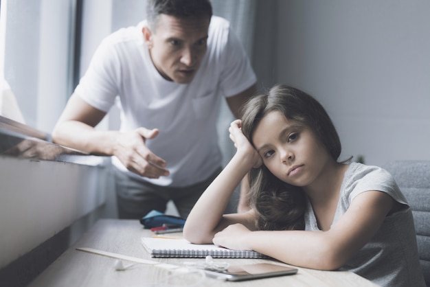 La bambina si siede al tavolo mentre father angers