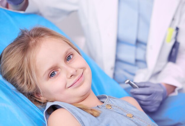 Little girl sitting in the dentists office