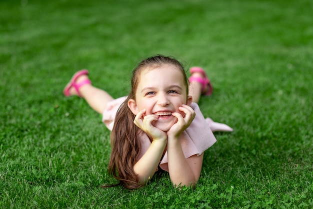 公園の芝生の上に座っている小さな女の子