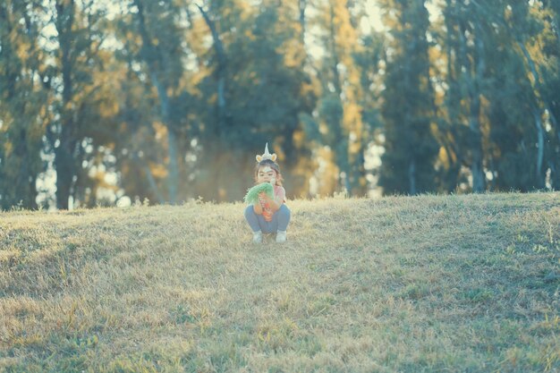 Photo little girl sitting on the grass