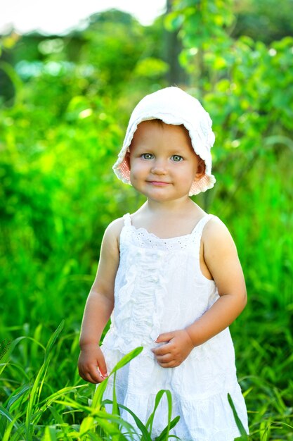 Little girl sitting in the green grass