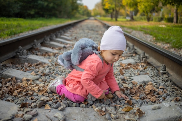 Little girl sitting on the railroad tracks