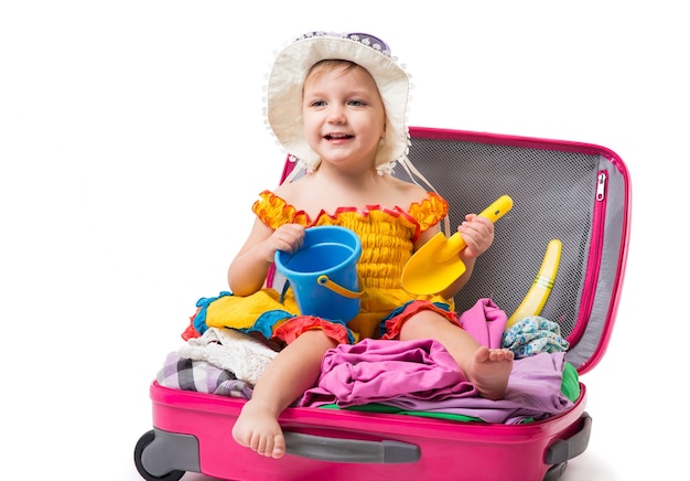 The little girl sitting on a suitcase