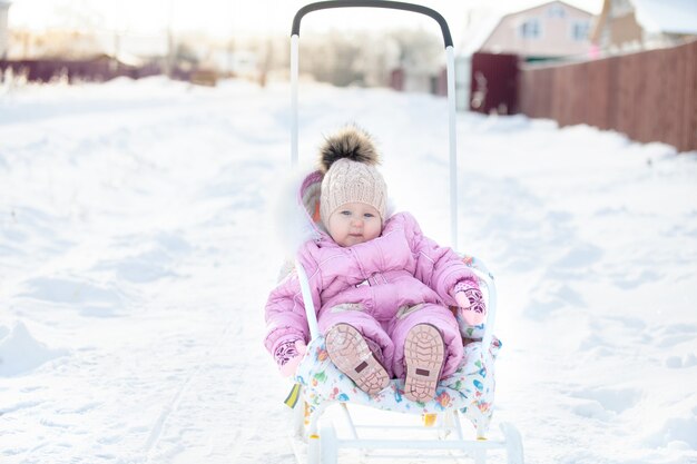 Little girl on sled on winter walk