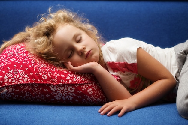 Photo little girl sleeps on a sofa, close up photo