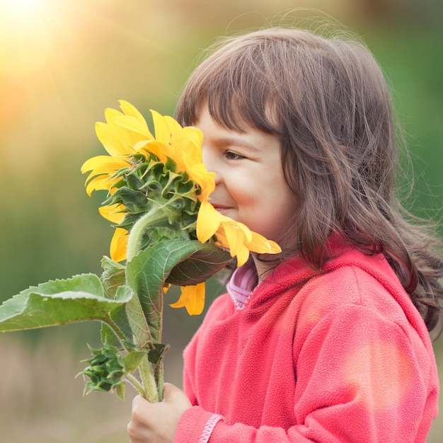 Bambina che odora di girasole