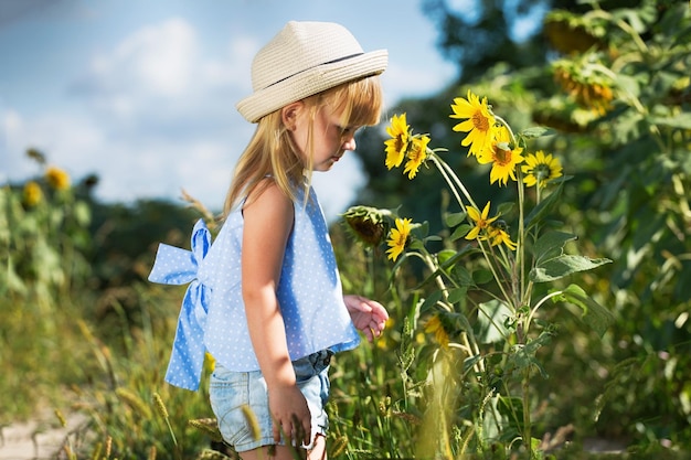 Bambina che sente l'odore di un girasole